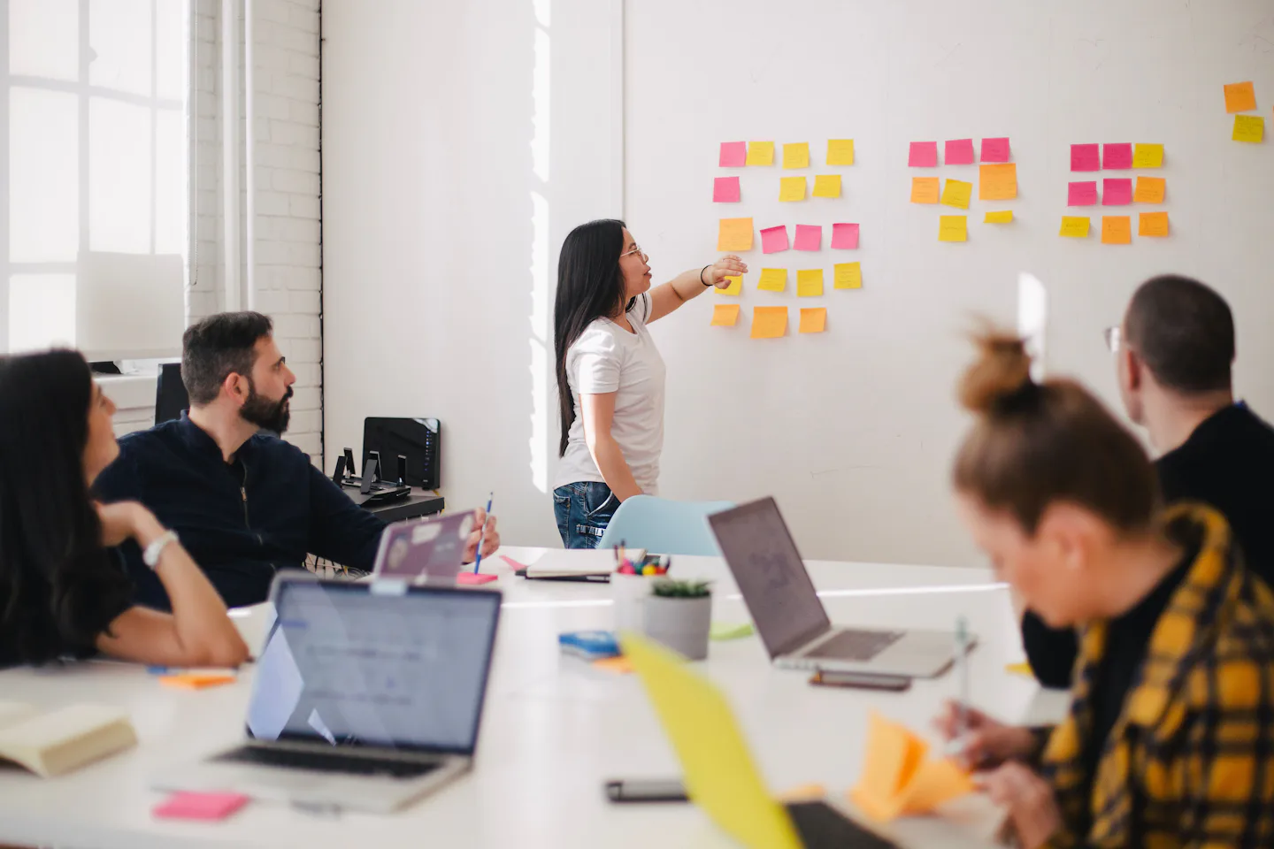 A team planning a project together with sticky notes on a whiteboard