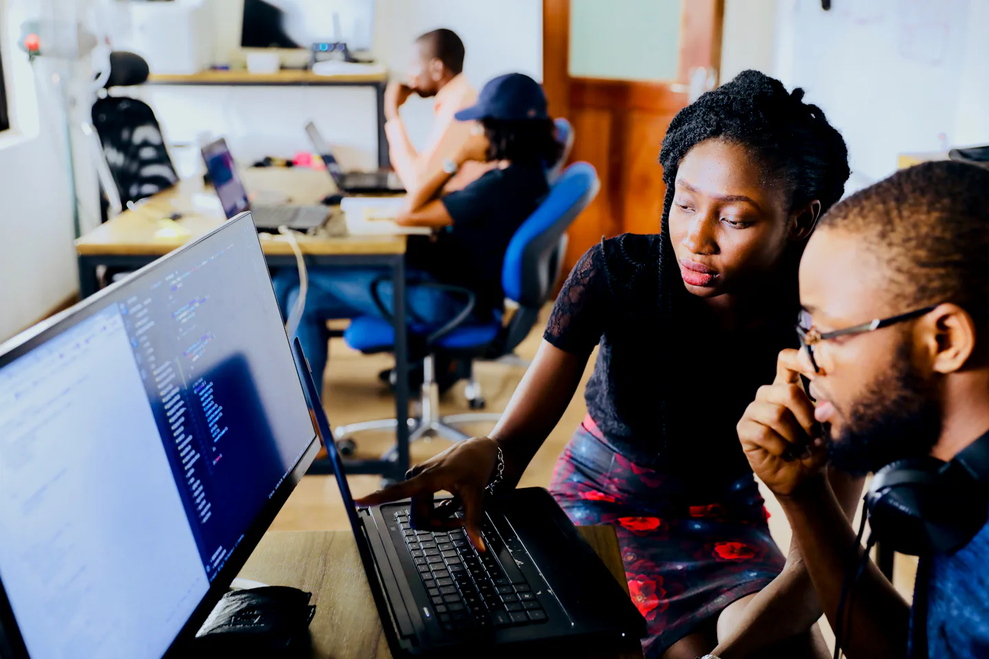Two developers working together on code at a laptop